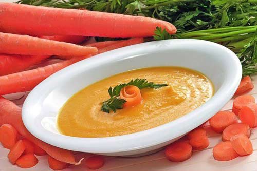 Натріть очищену моркву, додайте трохи родзинок, трохи лимонної цедри або цукатів, трошки товченого мигдалю, цукру, залийте окропом, варіть 8-10 хвилин